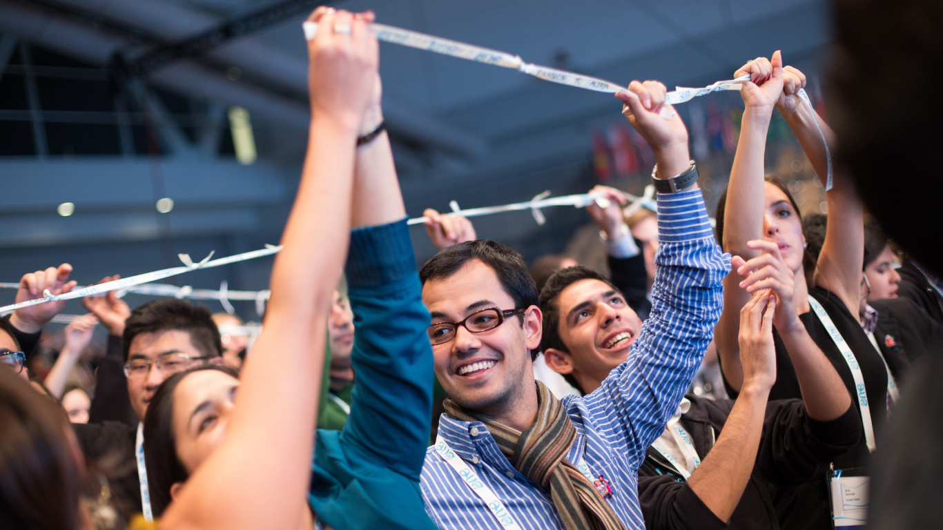 Delegates holding ribbons at the One Young World Summit closing ceremony