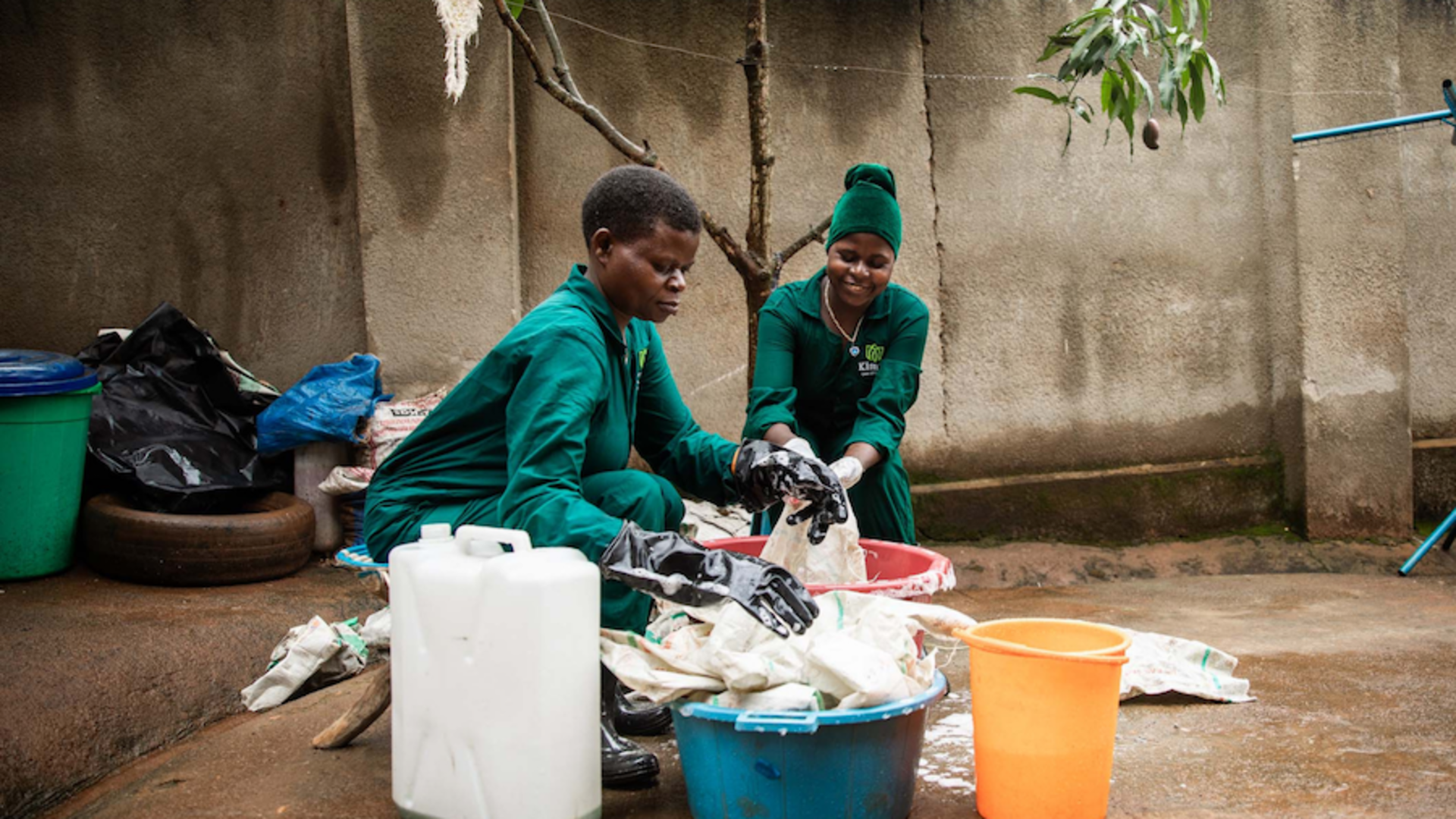 Two employees at Kimuli Collections, a project led by a One Young World Ambassador, cleaning upcycled clothes