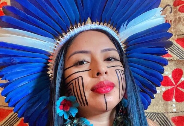 Maricelma Francelino Fialho Cândido wearing Indigenous headwear and face paint