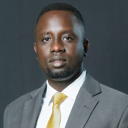 Portrait of Arthur Mugisha in grey suit and yellow tie