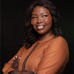 Portrait of Grace Garang in tan dress against black background