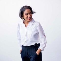 Portrait of Leila Omer in white shirt black trousers against white background